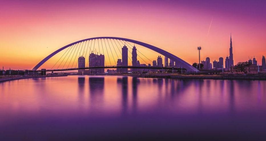 Dubai Water Canal - pink and purple hues with city scape and bridge